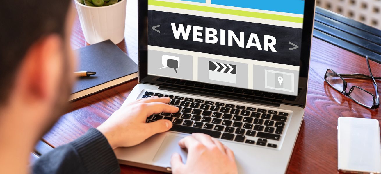 Webinar, online training and education, distance learning concept. Back view of a man working with a computer laptop, webinar text on the screen